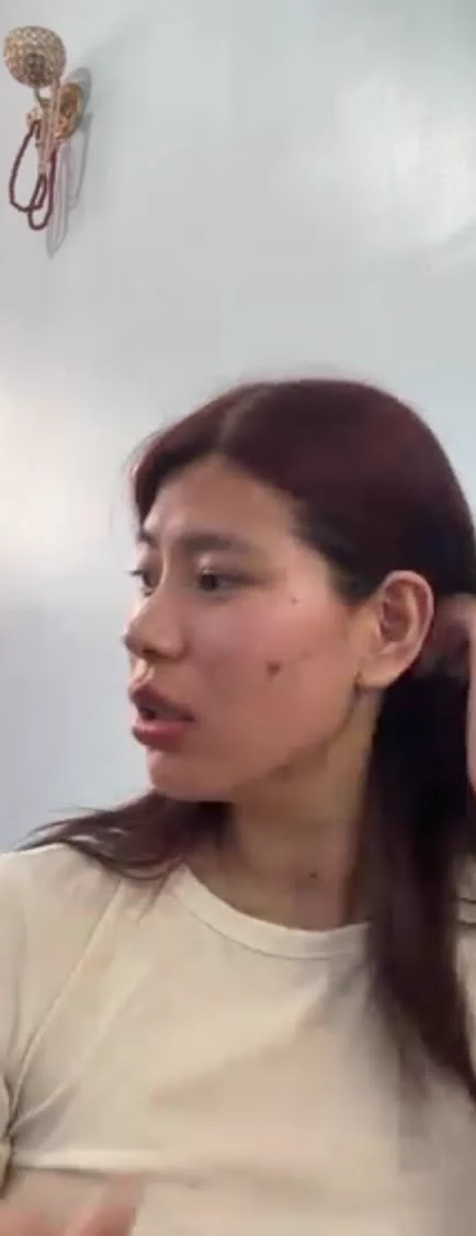 Sonam on a video call with one hand in her hair during a conversation.
