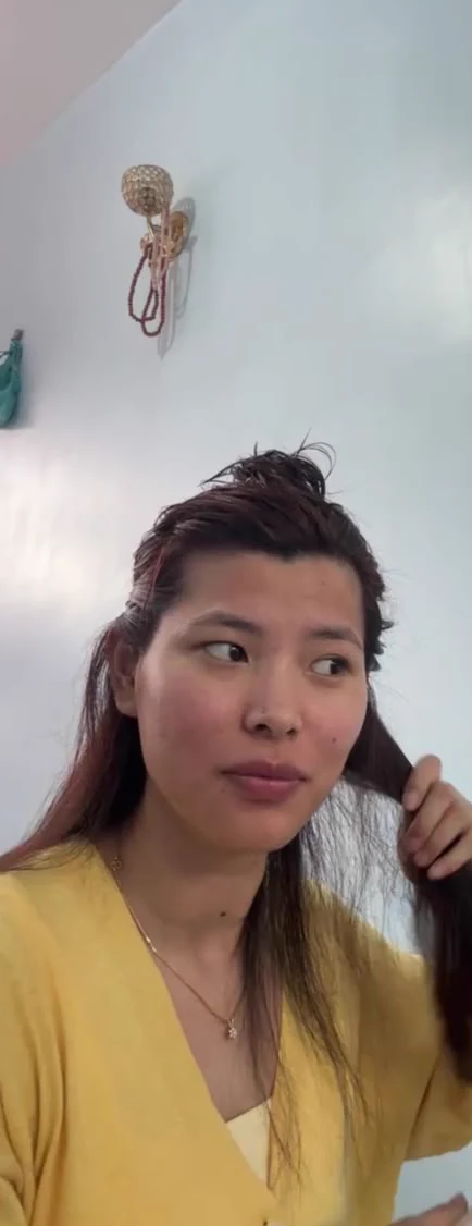 Sonam holding a section of her hair while getting ready during a video call.