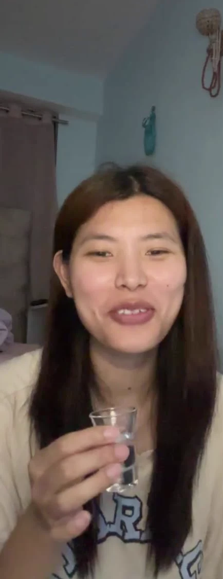 Sonam smiling on a video call while holding a small glass.