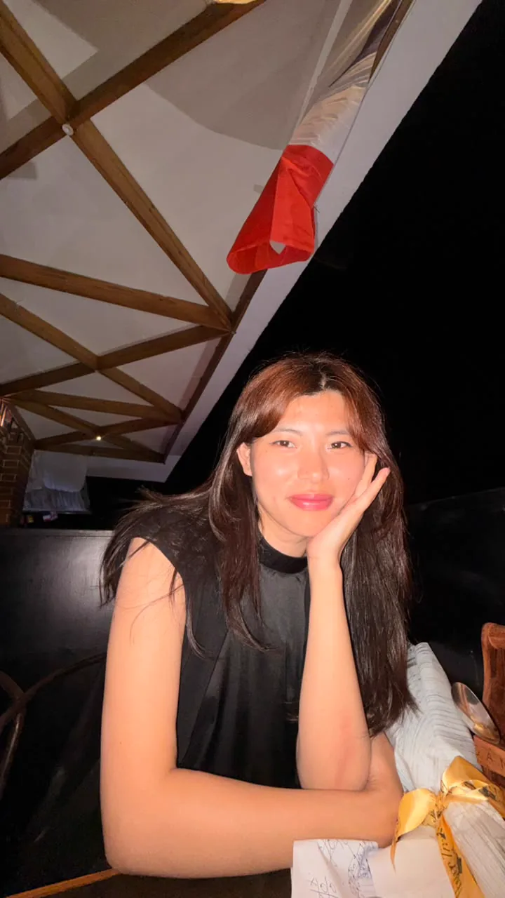 Sonam seated at the restaurant table with her head resting on one hand.
