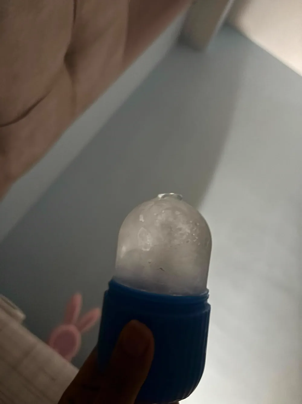 A piece of ice in a small blue holder.